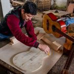 Reo reaviva tradición familiar fabricando guitarras en Tacumbú